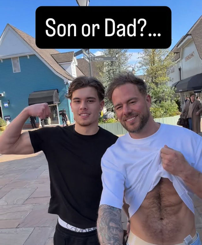 Controversial father-son adult content creators, posing outdoors, one lifting shirt. Controversial father-son adult content creators, posing outdoors, one lifting shirt.