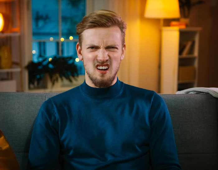 A man making a disgusted face on a couch. Contact a divorce lawyer for issues not related to cheating.