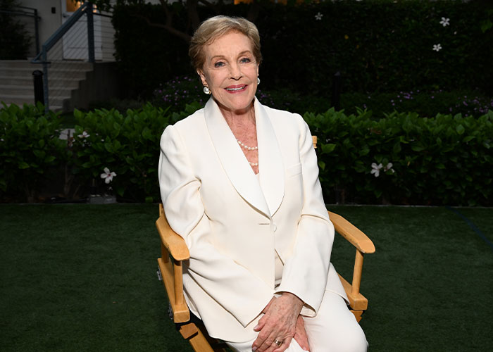 Julie Andrews in a glowing portrait, smiling while seated outdoors, sparking Disney backlash. Julie Andrews in a glowing portrait, smiling while seated outdoors, sparking Disney backlash.