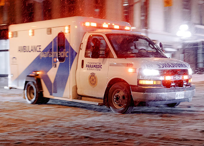 An ambulance drives with its lights on during the loneliest time, highlighting the sentiment of not looking forward to birthdays.