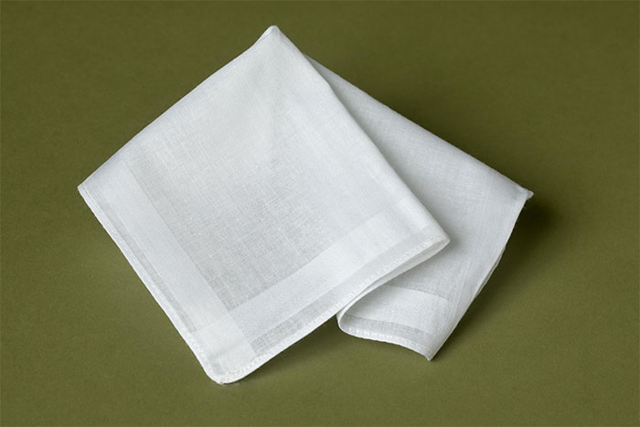 A folded white handkerchief on a green background. The girlfriend realized getting married was a mistake.
