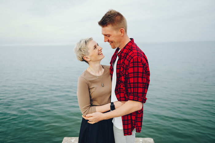 A happy couple embracing by the ocean, illustrating a positive age-gap relationship.