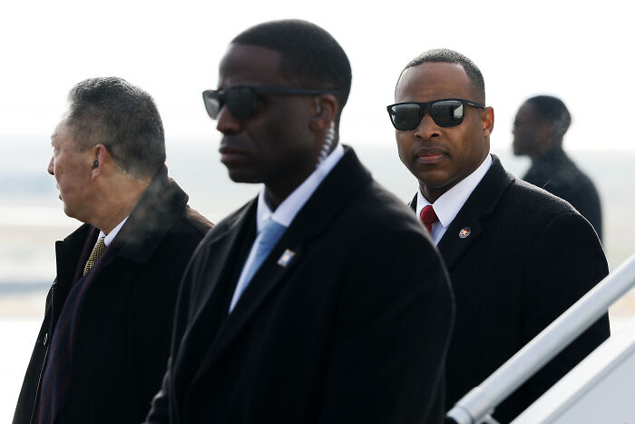 Two security guards in black suits and sunglasses, looking stern, related to stories of why people got fired from their jobs.