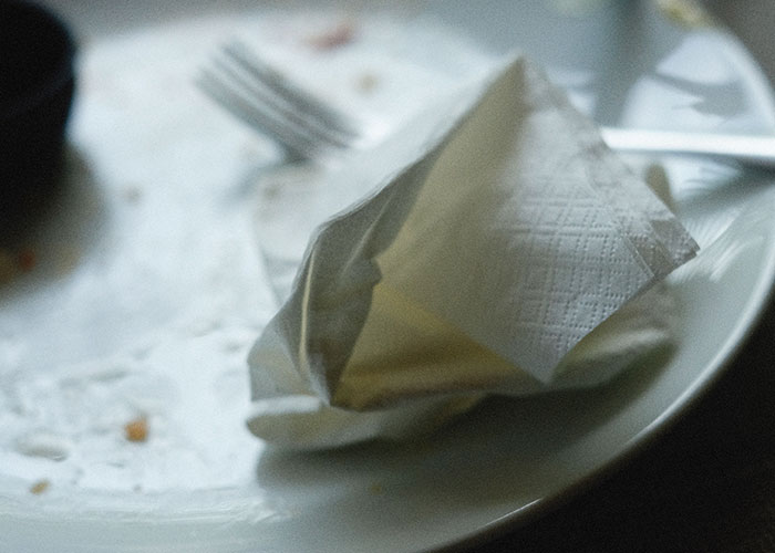 An empty, dirty plate with a used napkin, reflecting experiences of women leaving a man's home immediately.