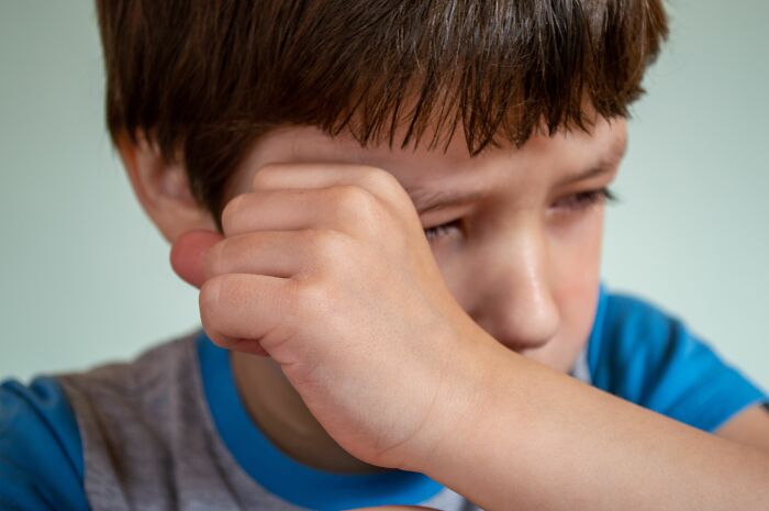 Close up of confused kid wiping tears from eyes parenting expert insights