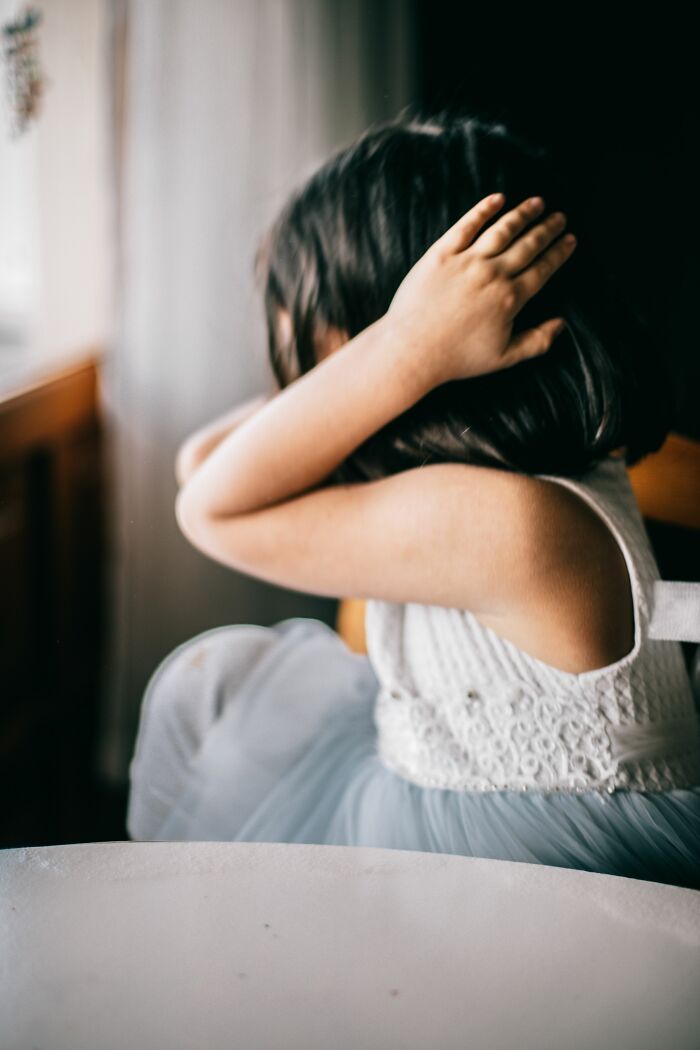 Parenting expert reveals a child covering their ears, symbolizing kids understanding and confusion.
