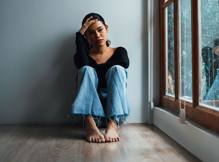 A woman sits on the floor, looking distressed about her DIL's and daughter's pregnancy competition and miscarriage. A woman sits on the floor, looking distressed about her DIL's and daughter's pregnancy competition and miscarriage.