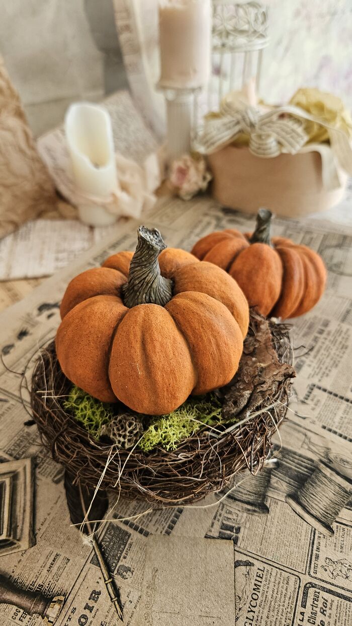 Handmade cotton wool pumpkins in a nest, showcasing artist's beautiful creations.
