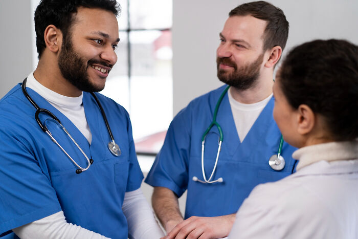 Three medical professionals in scrubs, representing jobs guys have that make women swipe left.