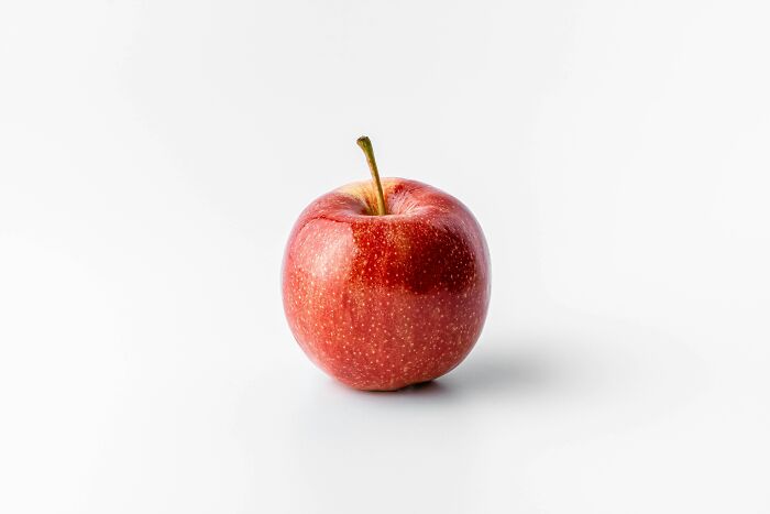 A single red apple on a white background, representing the simple yet profound questions kids ask.