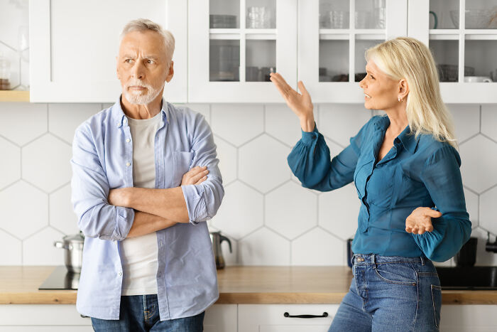An older man and younger woman argue in a kitchen, showing the struggles of age-gap relationships.