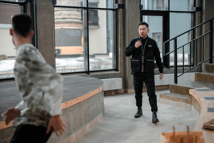 A man in a black uniform looking surprised, potentially getting fired from his job.