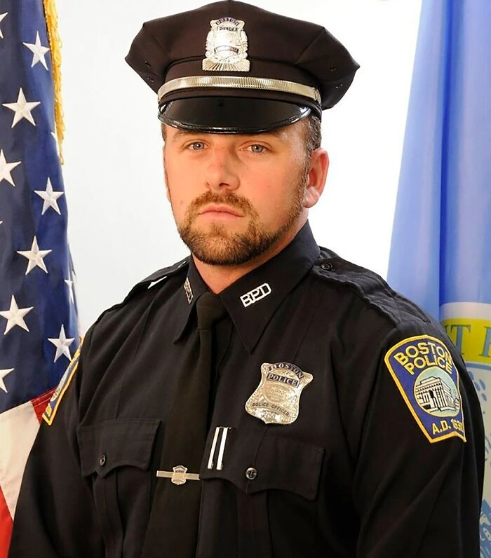A uniformed Boston police officer with a serious expression, featured in content about unsolved mysteries.
