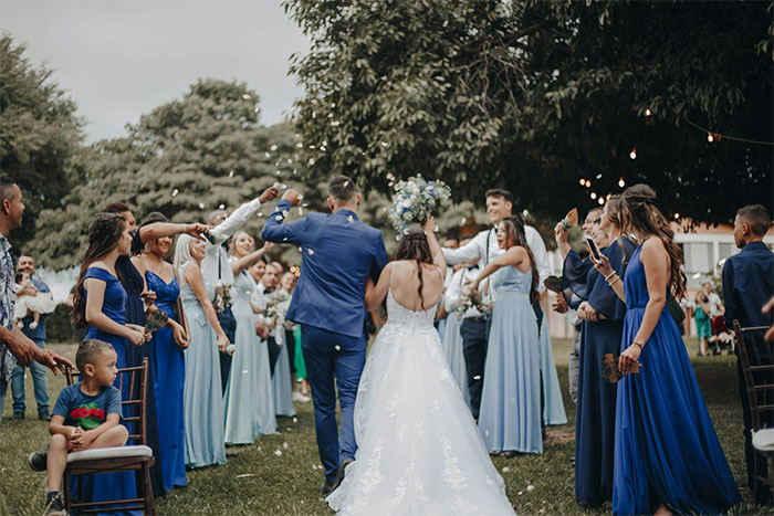 A wedding photo with a newly married couple walking down an aisle, surrounded by guests. The bride and groom are celebrating their union, symbolizing new beginnings after a crazy MIL's witchcraft.