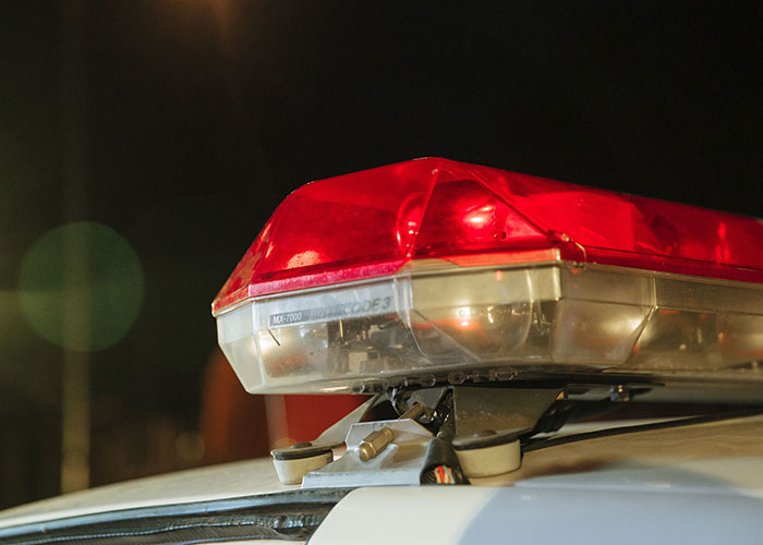 A close-up of a police car's flashing red siren lights, symbolizing the loneliest time or difficult birthdays.