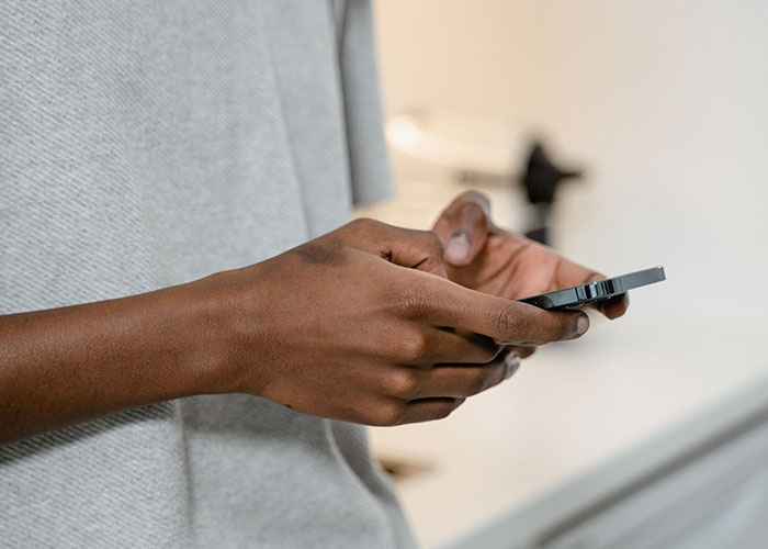 A person scrolls on their smartphone, experiencing the loneliest time, as they no longer look forward to their birthdays.