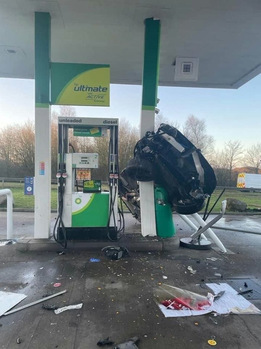 A black car crashed and lodged vertically against a gas pump at a BP station, showing a rough day behind the wheel.