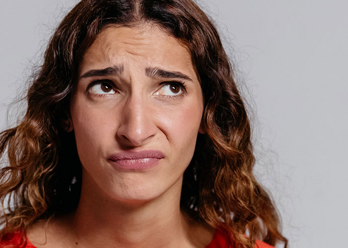 A woman making a disgusted face, representing women who had to leave immediately.