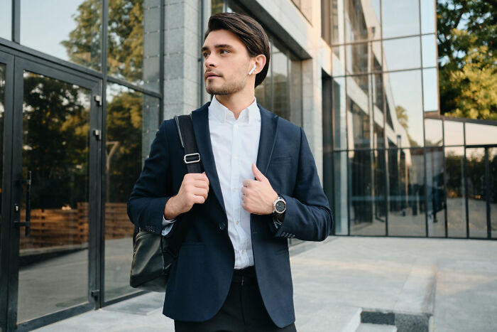 A man in a suit with a bag, considering jobs guys have that make women swipe left.