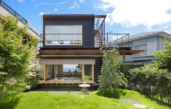 Beautiful modern architecture design for a multi-level home with large windows and a serene green garden.