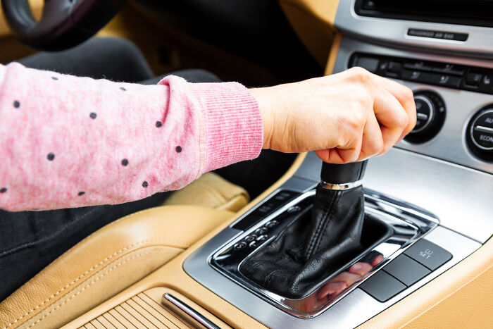 A person's hand shifting gears in a car, depicting the changing appeal of products and items.
