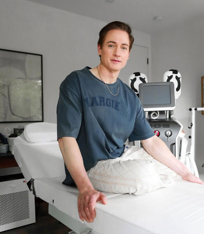 Biohacker Bryan Johnson sitting on an examination table, hinting at his longevity journey and claims of cloning himself. Biohacker Bryan Johnson sitting on an examination table, hinting at his longevity journey and claims of cloning himself.