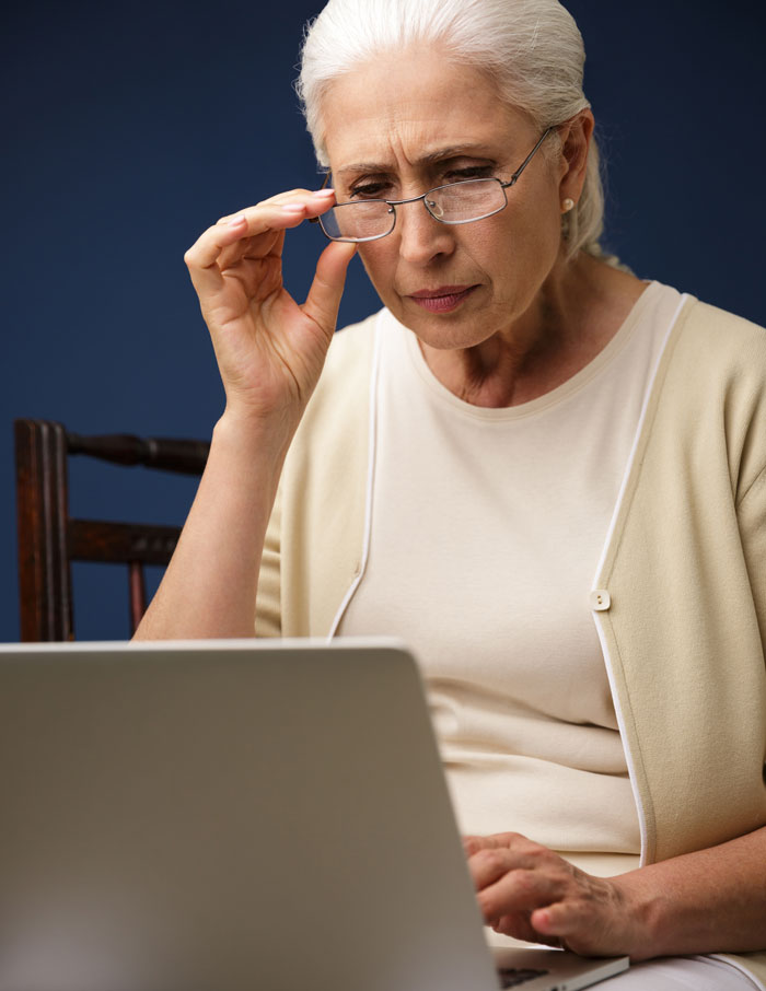 A frustrated mom making travel plans on her laptop, emphasizing the backfire of unconsulted family decisions.