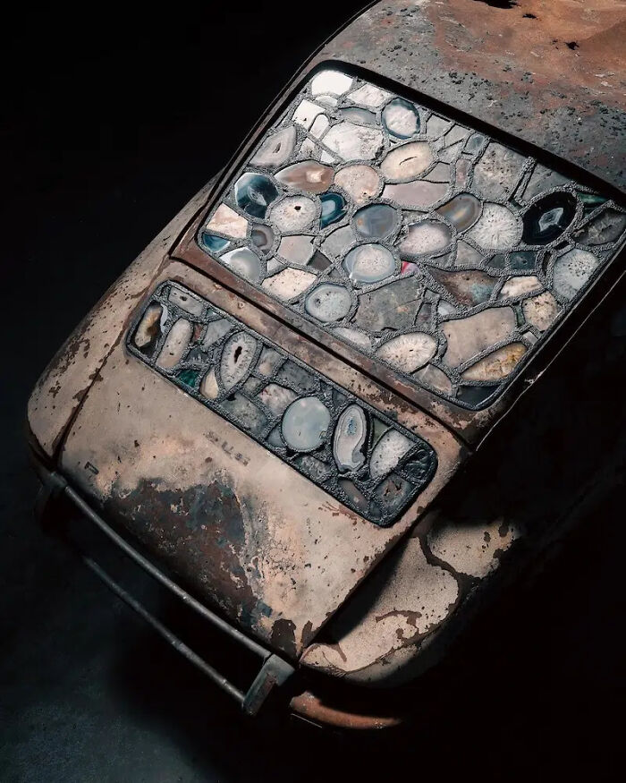 Close-up of the burned and rusted Porsche 911 with a stained-glass sculpture instead of a rear window.