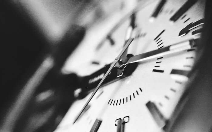 A close-up, black and white shot of a watch face with hands and markers, representing the concept of questions kids ask.