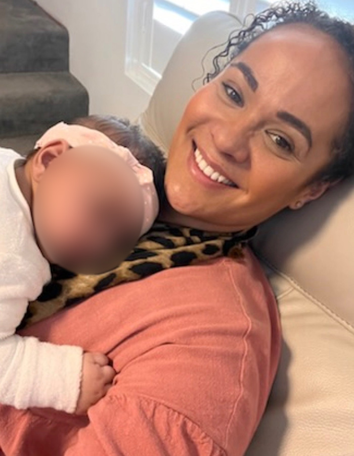 A smiling woman holding a baby, connected to the marshmallow accident news.