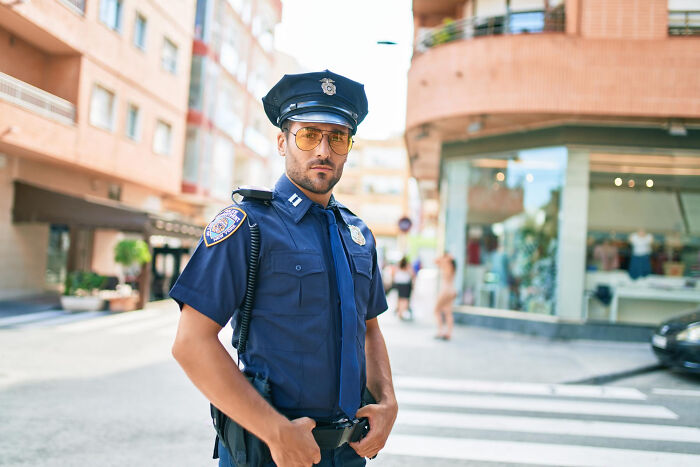 A police officer on a street, symbolizing jobs guys have that make women swipe left.
