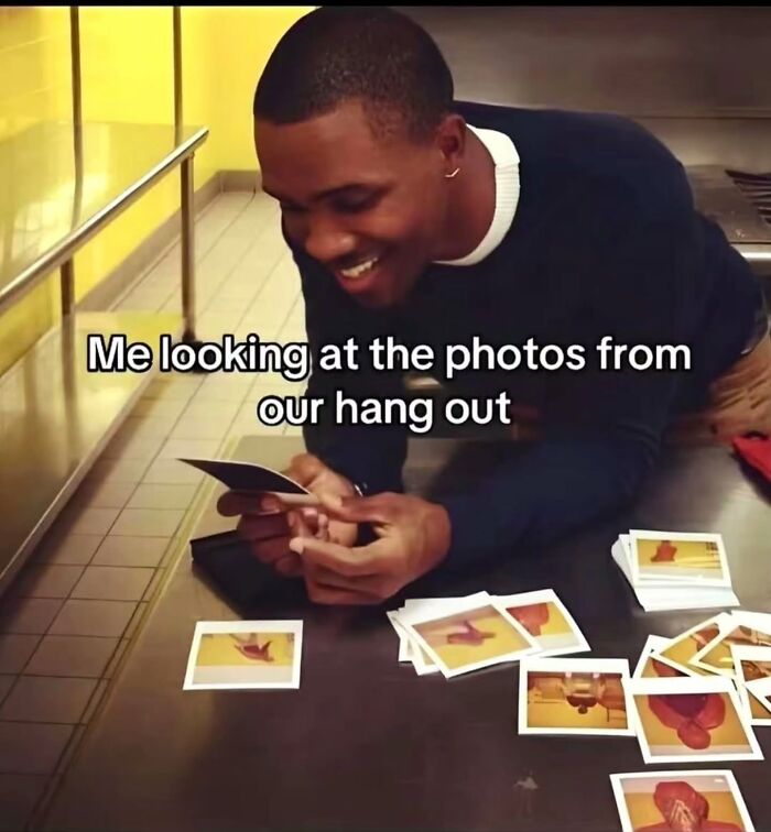 A man smiles while looking at photos, a relatable meme about happy memories.