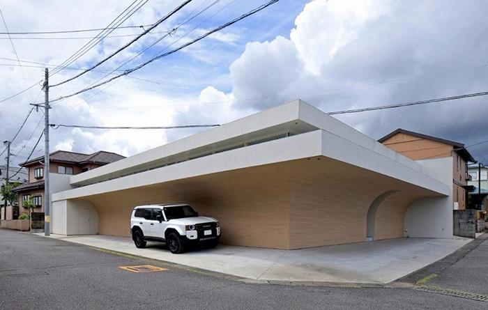 Modern architecture design: A sleek, modern house with a curved wooden facade and a white upper level, with a white SUV parked outside.