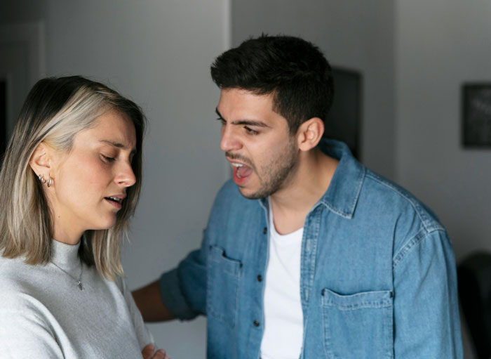 A man yelling at a woman, representing the man punishing his nephew for punching his baby daughter.