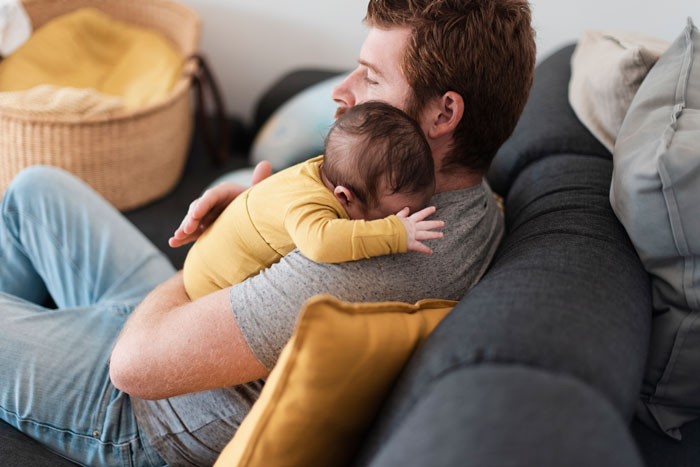 A man holds his baby daughter. The man punishes nephew for punching his baby daughter again. Family says he should stay out of it.