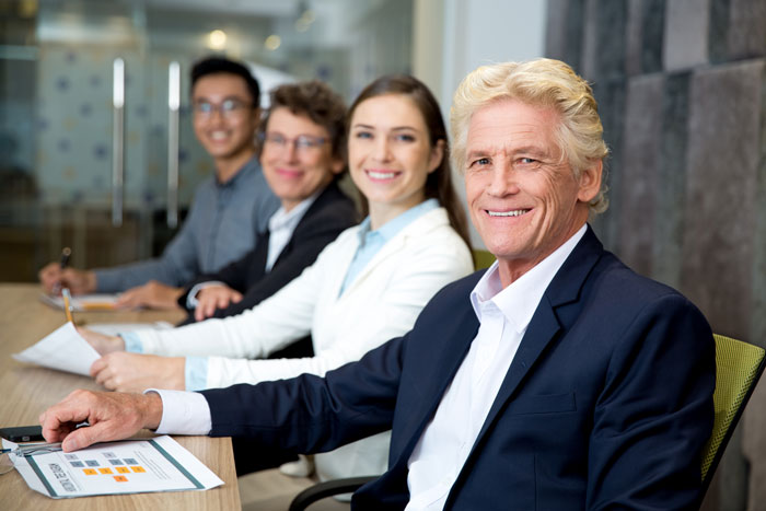 Smiling professionals in a meeting, representing the people involved in a coworker rejection incident. Smiling professionals in a meeting, representing the people involved in a coworker rejection incident.