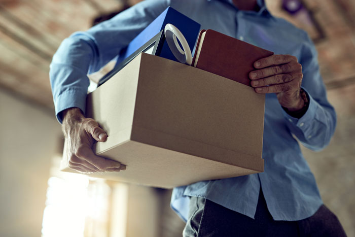 A coworker ends his job by carrying a box of his belongings after being rejected by a colleague. A coworker ends his job by carrying a box of his belongings after being rejected by a colleague.