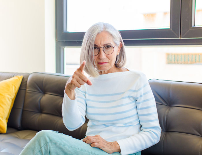 An elderly woman with a MIL face, wearing glasses, pointing a finger, and sitting on a black sofa. This MIL turned DIL's pregnancy into a competition and showed no sympathy for the DIL's miscarriage. An elderly woman with a MIL face, wearing glasses, pointing a finger, and sitting on a black sofa. This MIL turned DIL's pregnancy into a competition and showed no sympathy for the DIL's miscarriage.