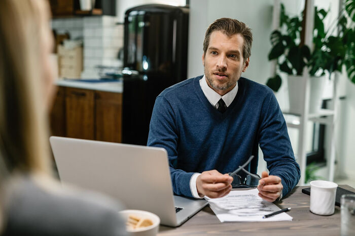 A man in a blue sweater talks, discussing jobs guys have that make women swipe left.