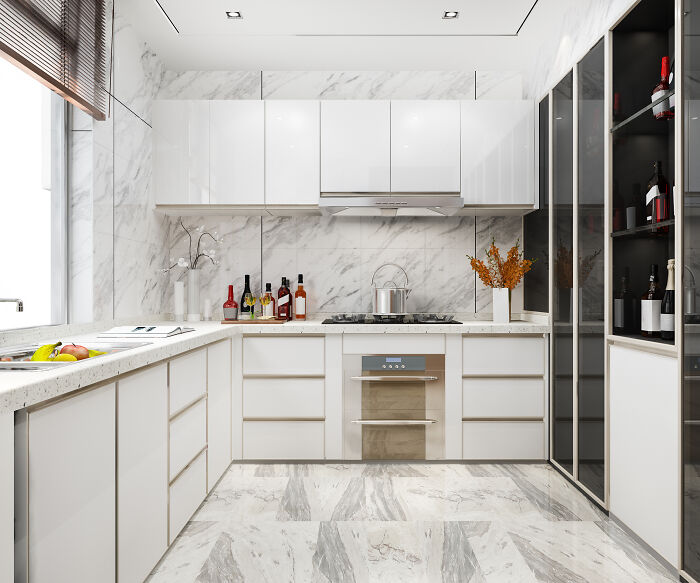 A modern, clean kitchen with white cabinets and marble backsplash, representing guests ignoring house etiquette.