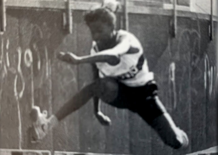 A young track star in mid-air during a hurdle race, reflecting Olympic dreams tragically cut short, exposing the truth. A young track star in mid-air during a hurdle race, reflecting Olympic dreams tragically cut short, exposing the truth.