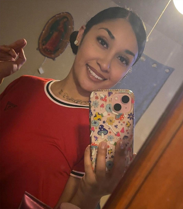 Woman taking a mirror selfie, main keyword for this image is brutal attack by smiling sisters.