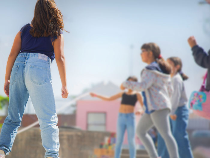 Children playing outside, viewed from behind a girl, depicting a situation related to clever comebacks.