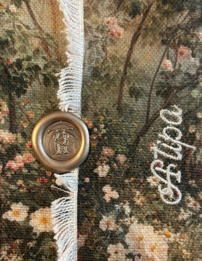 Photos leaked from Taylor Swift and Travis Kelce's wedding, showing a wax seal on floral fabric with T+T monogram.