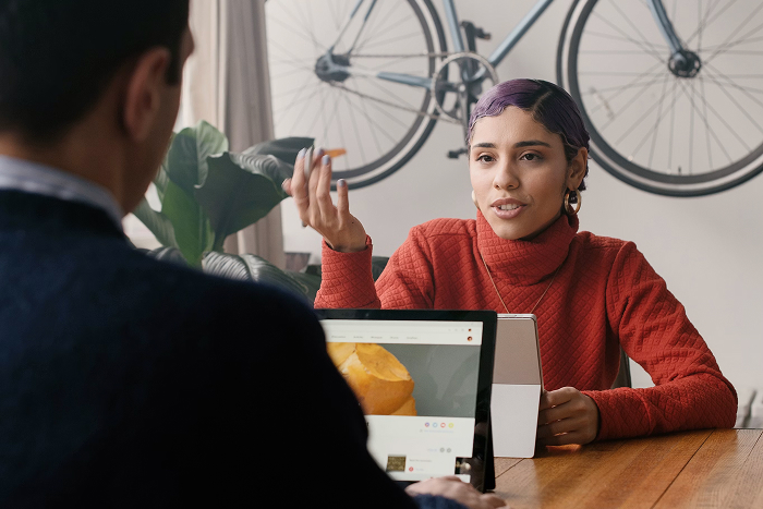 A woman with purple hair explaining something to a man, illustrating one of the mansplaining examples.
