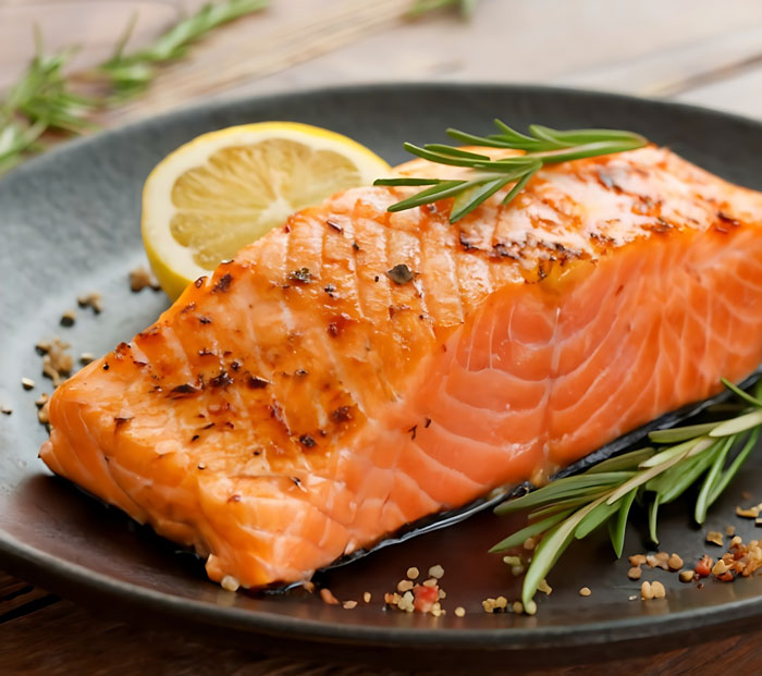 A perfectly cooked salmon fillet with lemon and rosemary, a surprisingly affordable gourmet meal.
