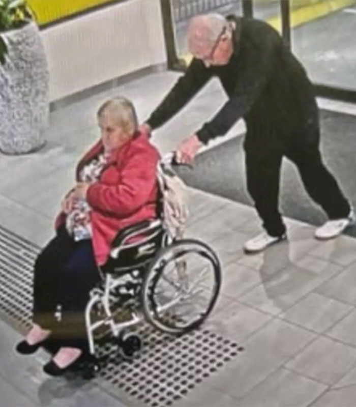 Elderly couple escaping care home, man pushing woman in a wheelchair. Elderly couple escaping care home, man pushing woman in a wheelchair.