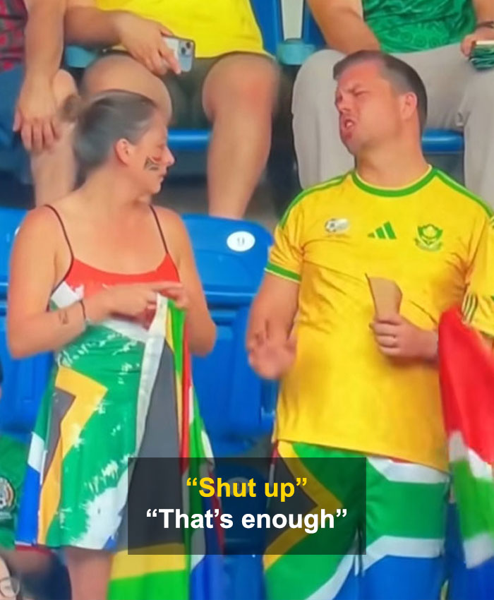 The World Cup couple during their viral moment, as the man responds to his partner's questions about his phone. The World Cup couple during their viral moment, as the man responds to his partner's questions about his phone.