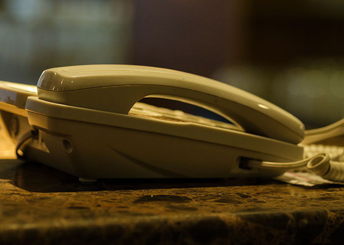 A close-up of an old landline phone, appearing to show a reality break.