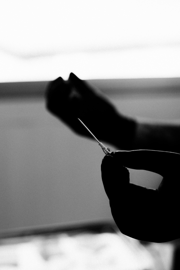 A person in silhouette holding a needle, suggesting something creepy or mysterious that happened to people.